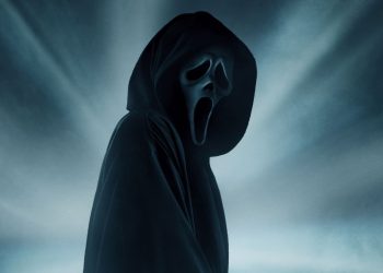 O assassino de pânico está ao centro da tela, de costas para o lado esquerdo da imagem. Ao fundo, há uma iluminação cinza que o cerca.