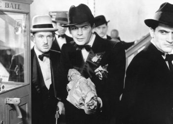 Tony Camonte (Paul Muni) aponta uma Tommy Gun para um de seus adversários ao lado de capangas nesta cena de Scarface.
