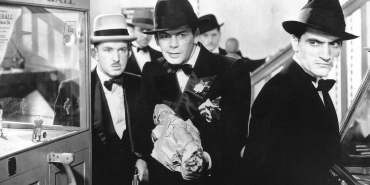 Tony Camonte (Paul Muni) aponta uma Tommy Gun para um de seus adversários ao lado de capangas nesta cena de Scarface.